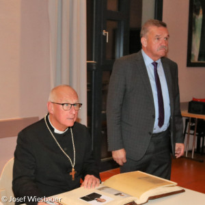 Regionalbischof Stiegler trägt sich ins Goldene Buch ein